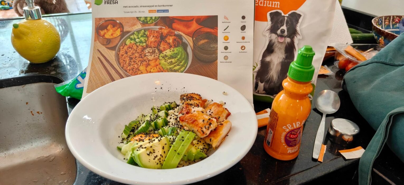 Pokébowl met gefrituurde kip, avocado, sinaasappel en komkommer