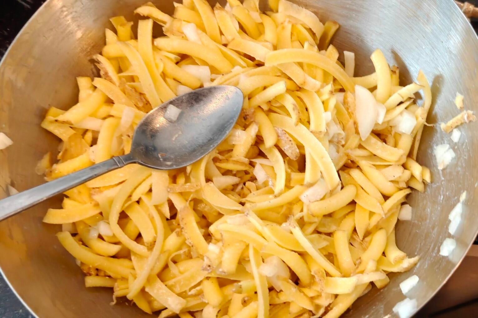 Kom met aardappel in dunne reepjes en gesnipperde ui, gesneden met de keukenmachine