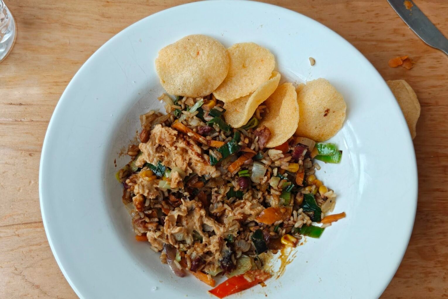 Bord met simpele nasi met pindasaus, adukibonen, roerbakgroenten en krupuk van Ekomenu